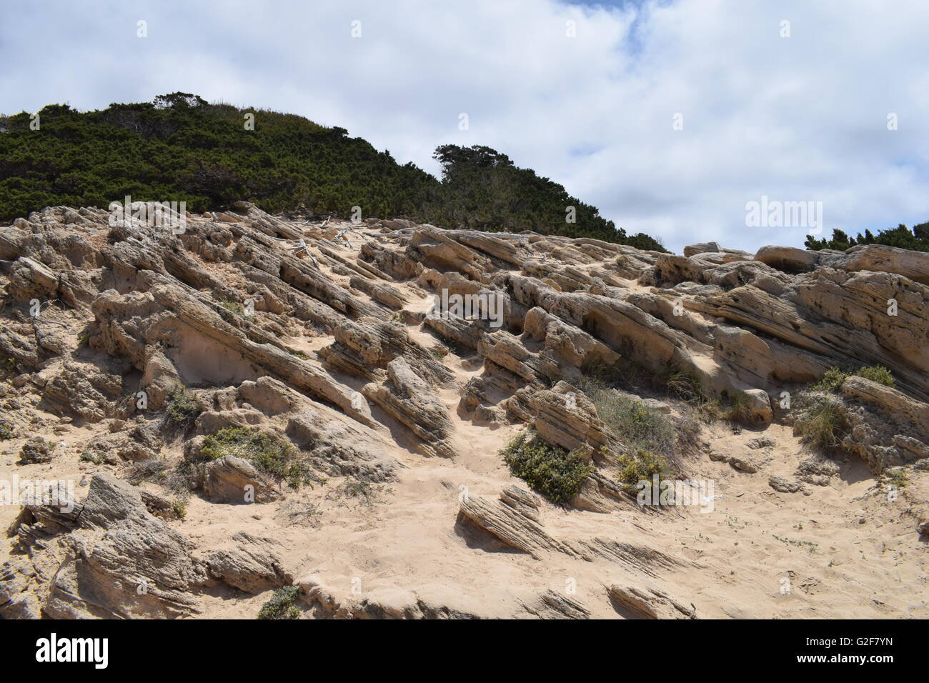 Layers of rocks on the coastal path towards the cove at Calo Des Mort ...