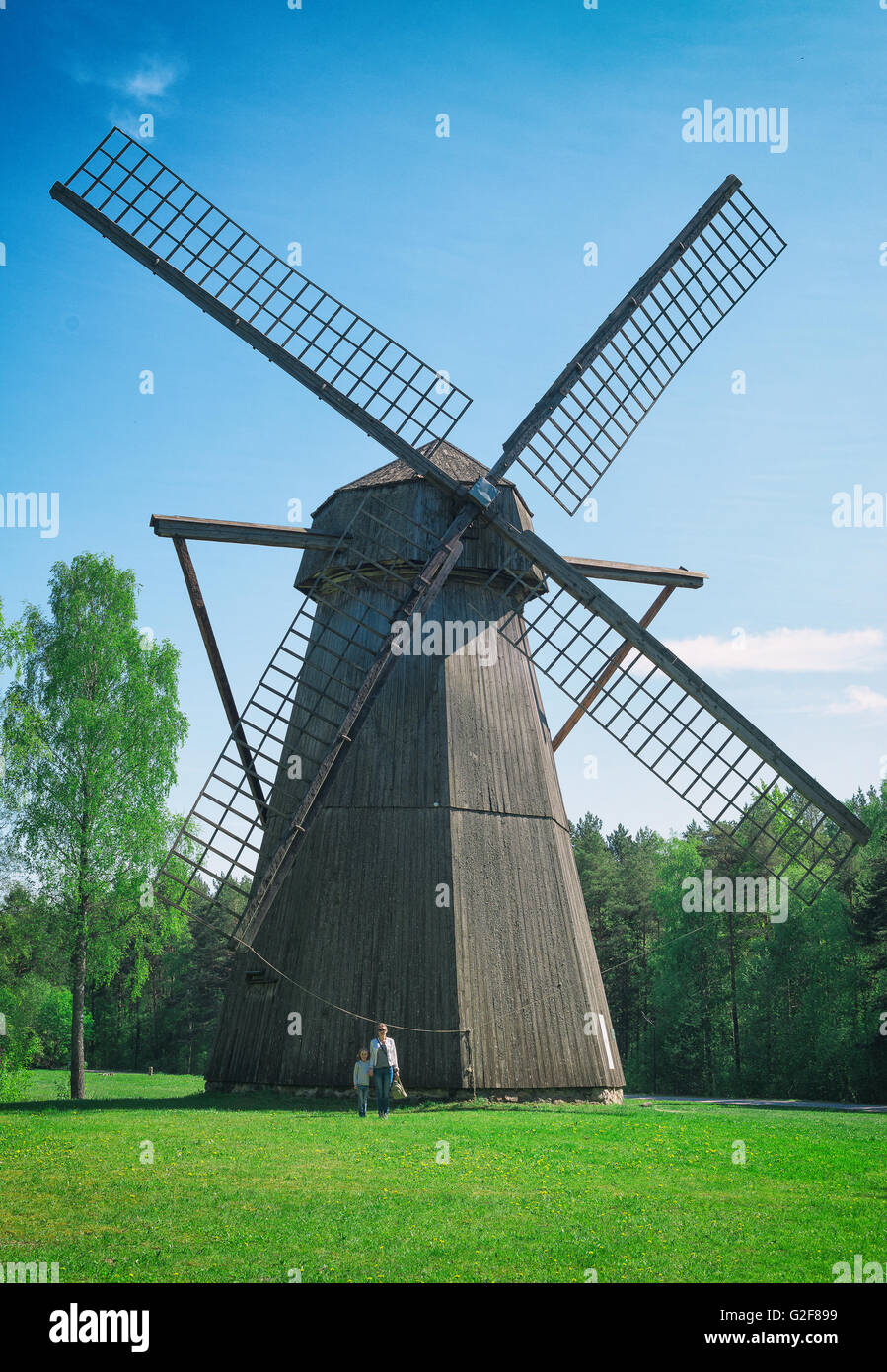 Old estonian windmill with two people. Size matters! Stock Photo