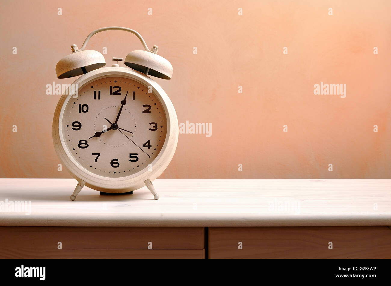 white vintage alarm clock on a wood table Stock Photo Alamy