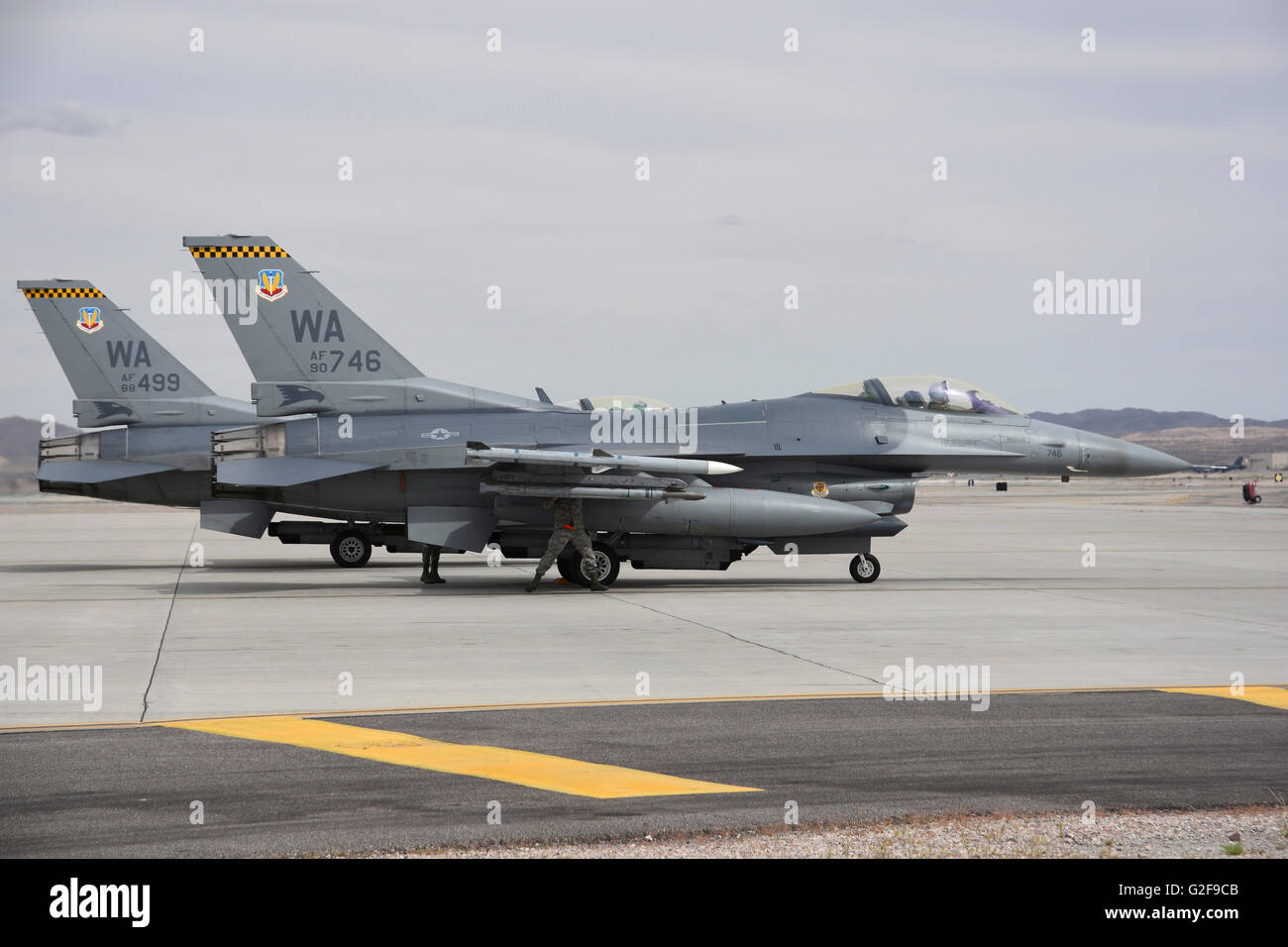 Two U.S. Air Force F-16C airplanes from 16th Weapons Squadron, 57th Wing, undergo preflight checks at Nellis Air Force Base, Nev Stock Photo
