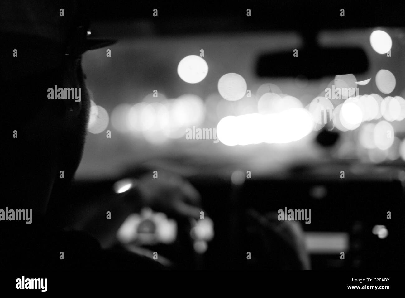 Man Driving Car at Night, Close-Up, Rear View Stock Photo