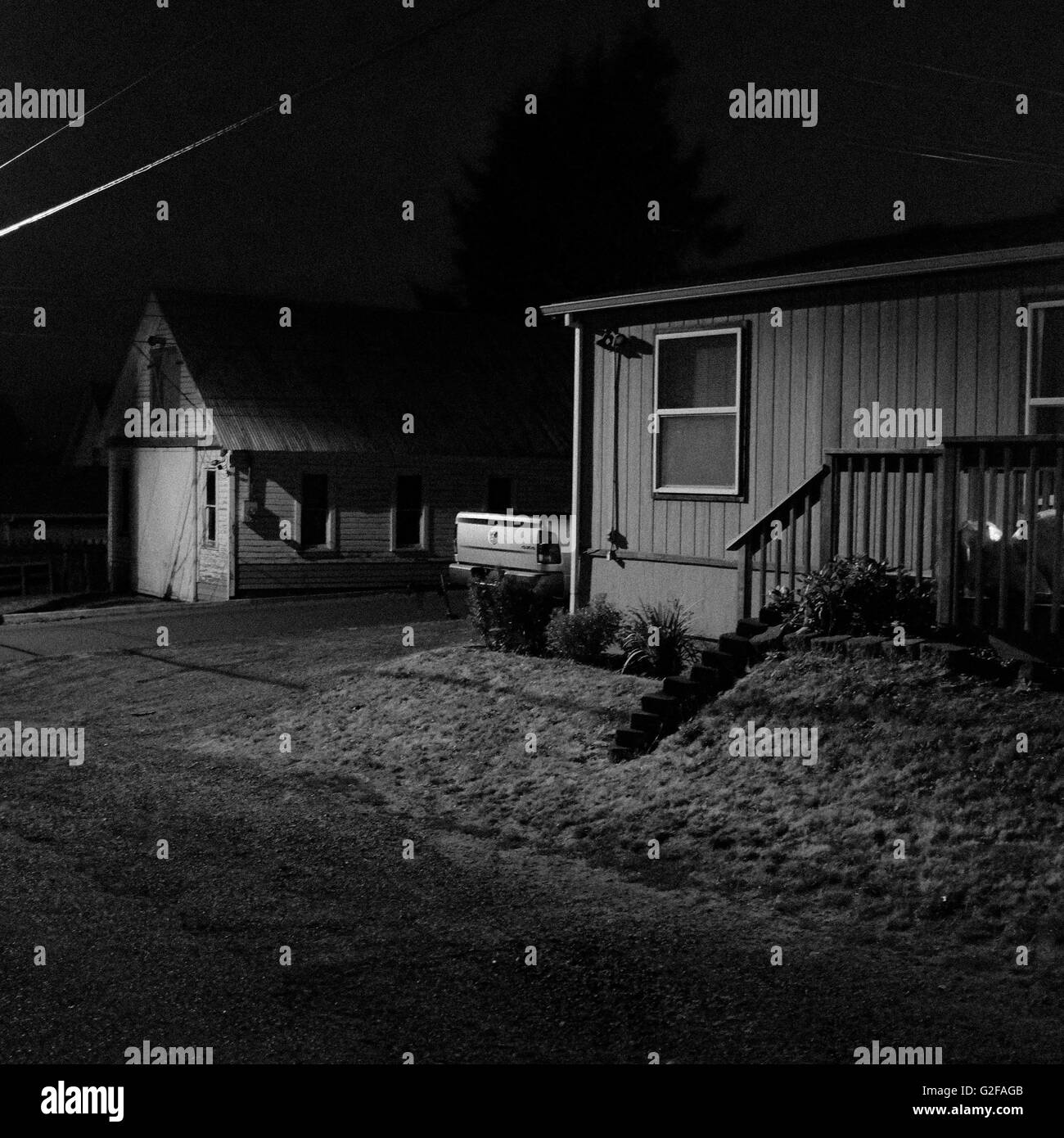 Small Suburban House And Detached Garage At Night Stock Photo