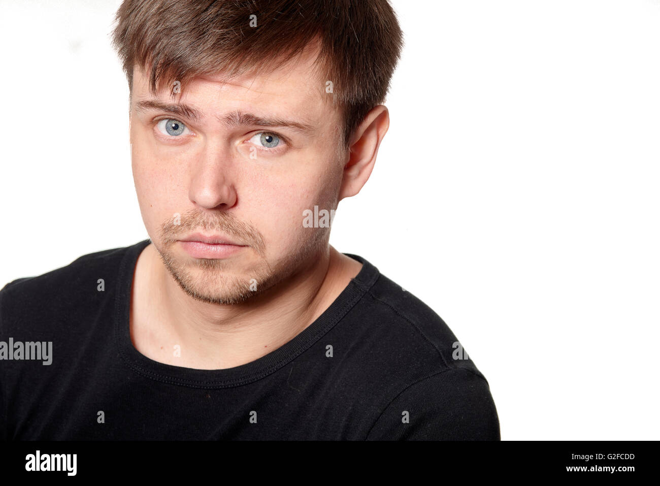 Serious young man, questioning expression,horizontal  on white background with space for text Stock Photo