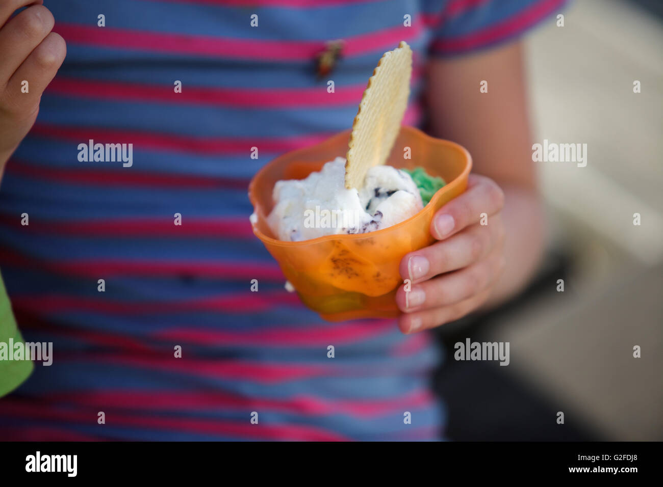 Little Boy child enjoying his cup of ice cream and waffle Stock Photo