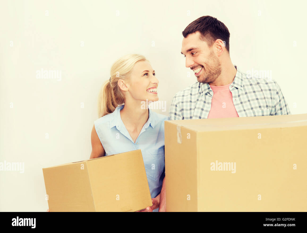 couple with cardboard boxes moving to new home Stock Photo - Alamy
