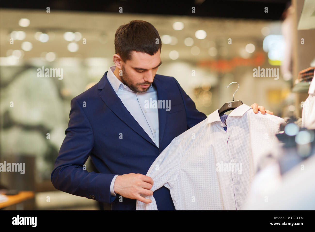 happy young man choosing clothes in clothing store Stock Photo - Alamy