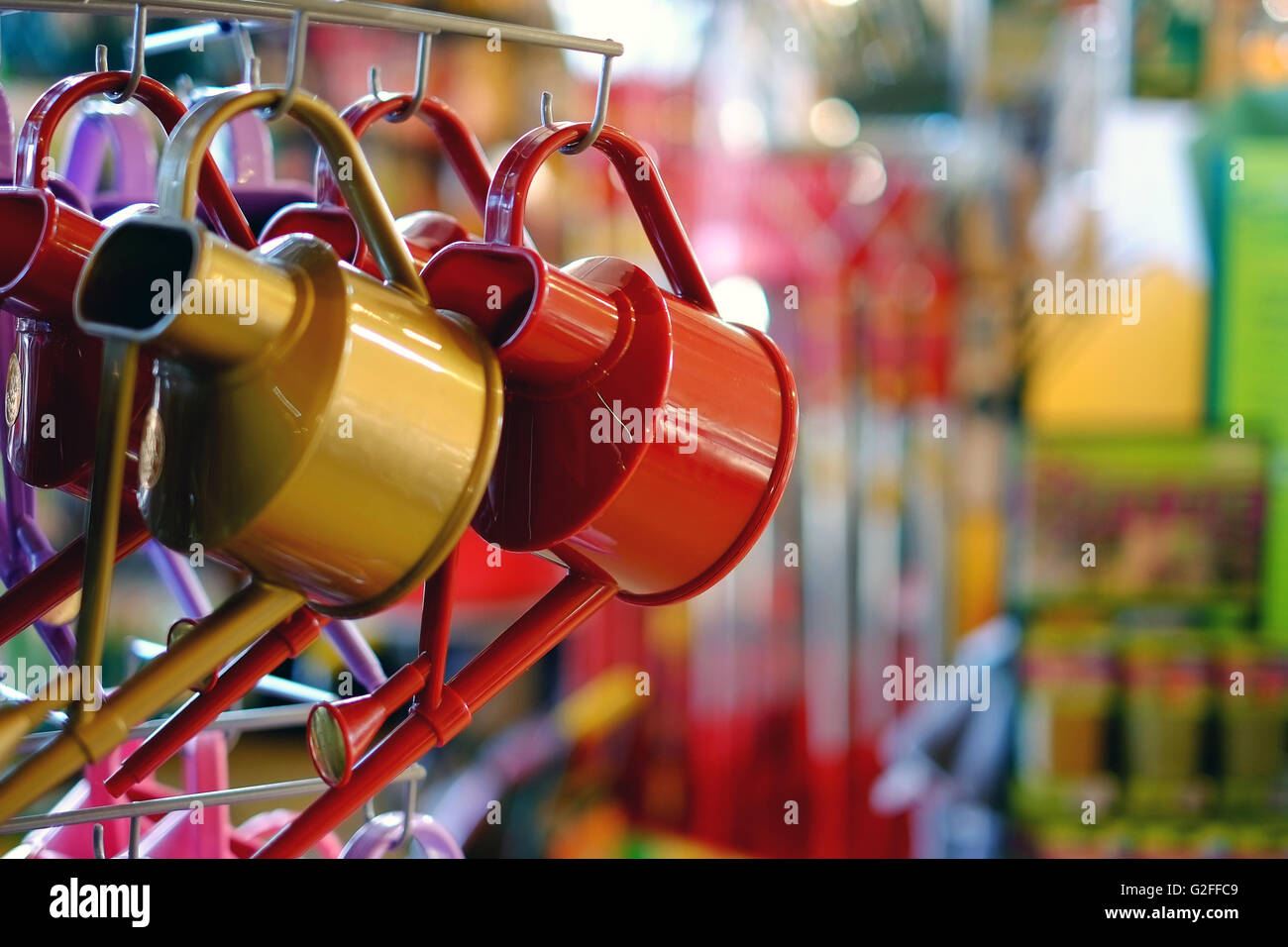 Watering cans in a garden centre shop. Stock Photo