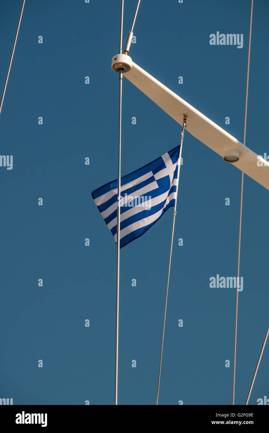 Greek flag floating in the wind on yacht moored docked at Zea Marina near Piraeus Port in Athens, Greece. Stock Photo