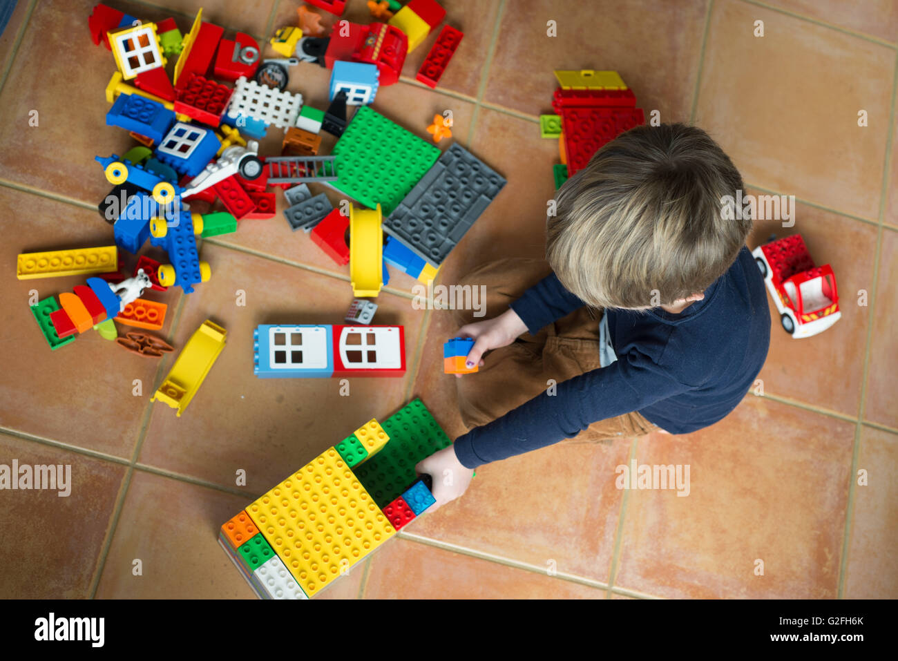 Overhead shot of boy playing with Duplo Stock Photo