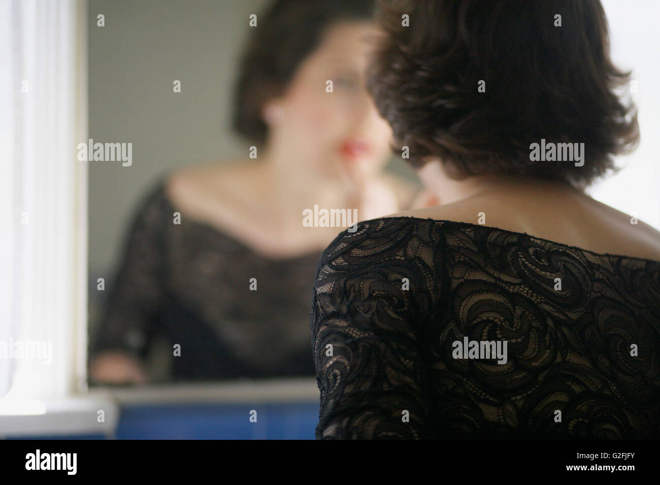 Woman Applying Lipstick in Mirror Stock Photo - Alamy
