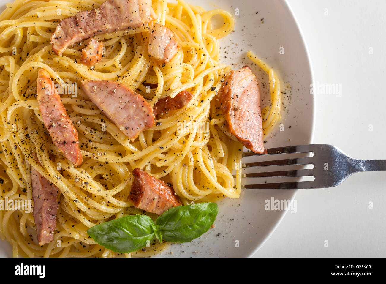 Spaghetti carbonara on white plate with fork Stock Photo