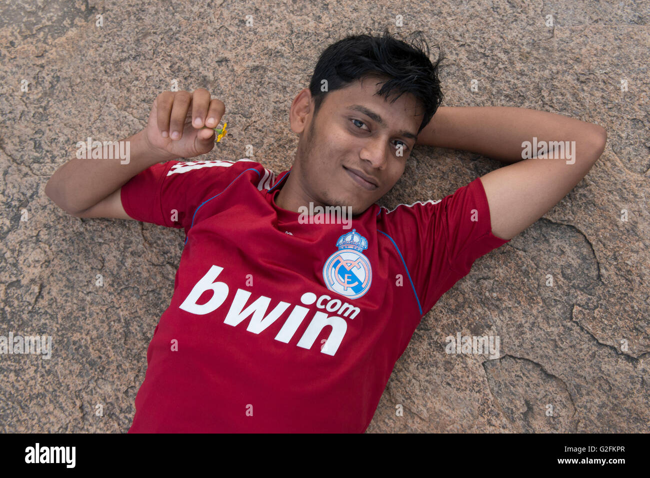 Young Man Having A Rest, Krishna's Butter Ball At Sunset, Mamallapuram (Mahabalipuram) Stock Photo