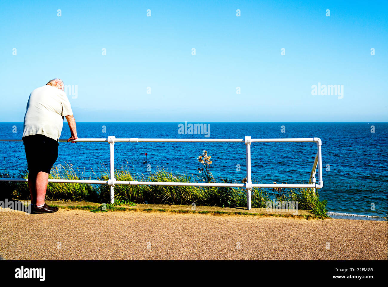 man leaning at a railing near the beach Stock Photo - Alamy