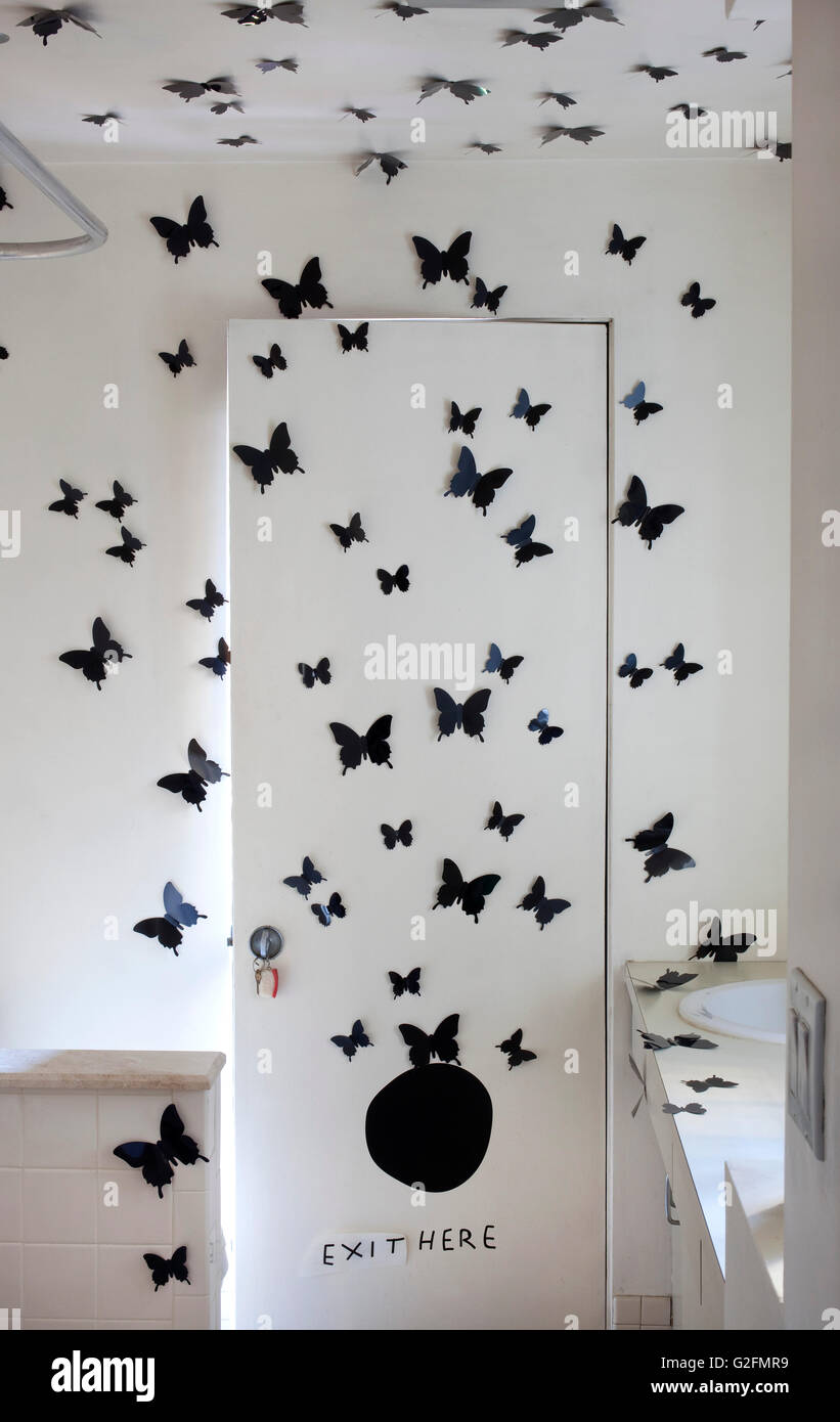 Bathroom door decorated with paper butterflies Stock Photo