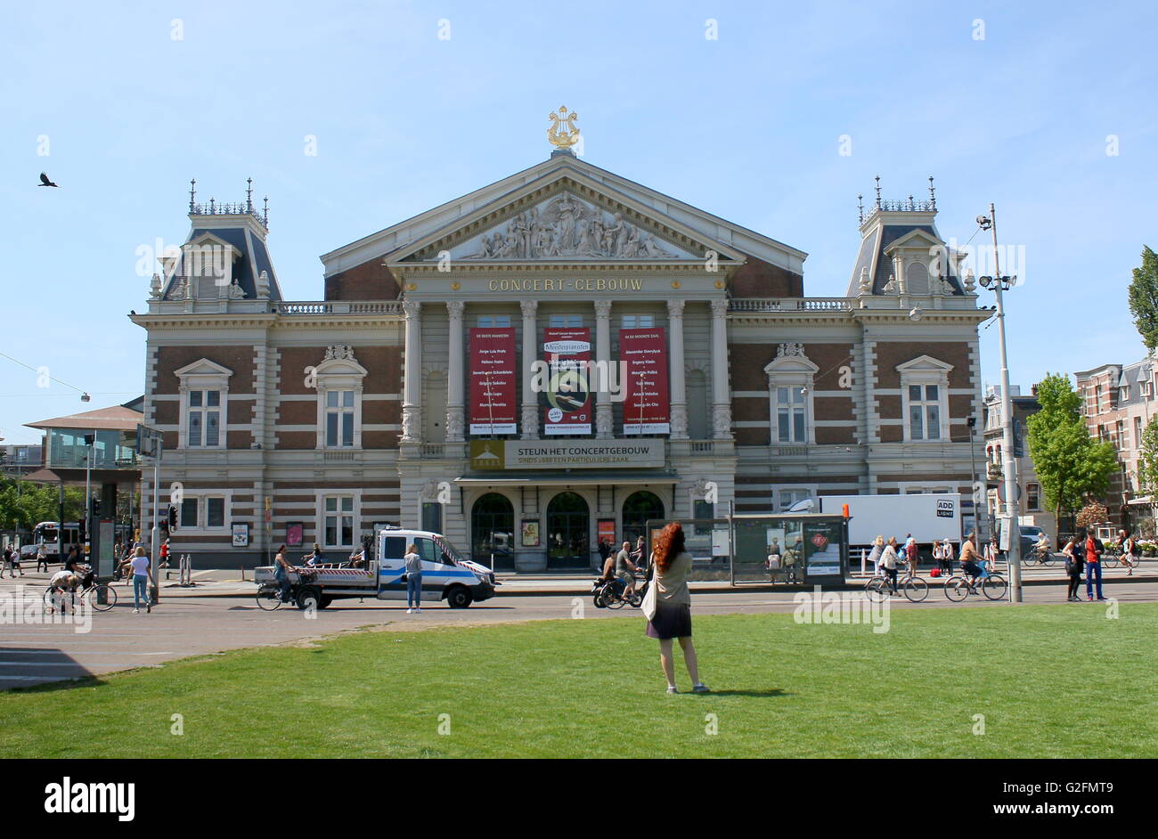 Tourist girl taking a photo of the Koninklijk Concertgebouw (Royal Concert Hall), Museum square,  Amsterdam, Netherlands. Stock Photo