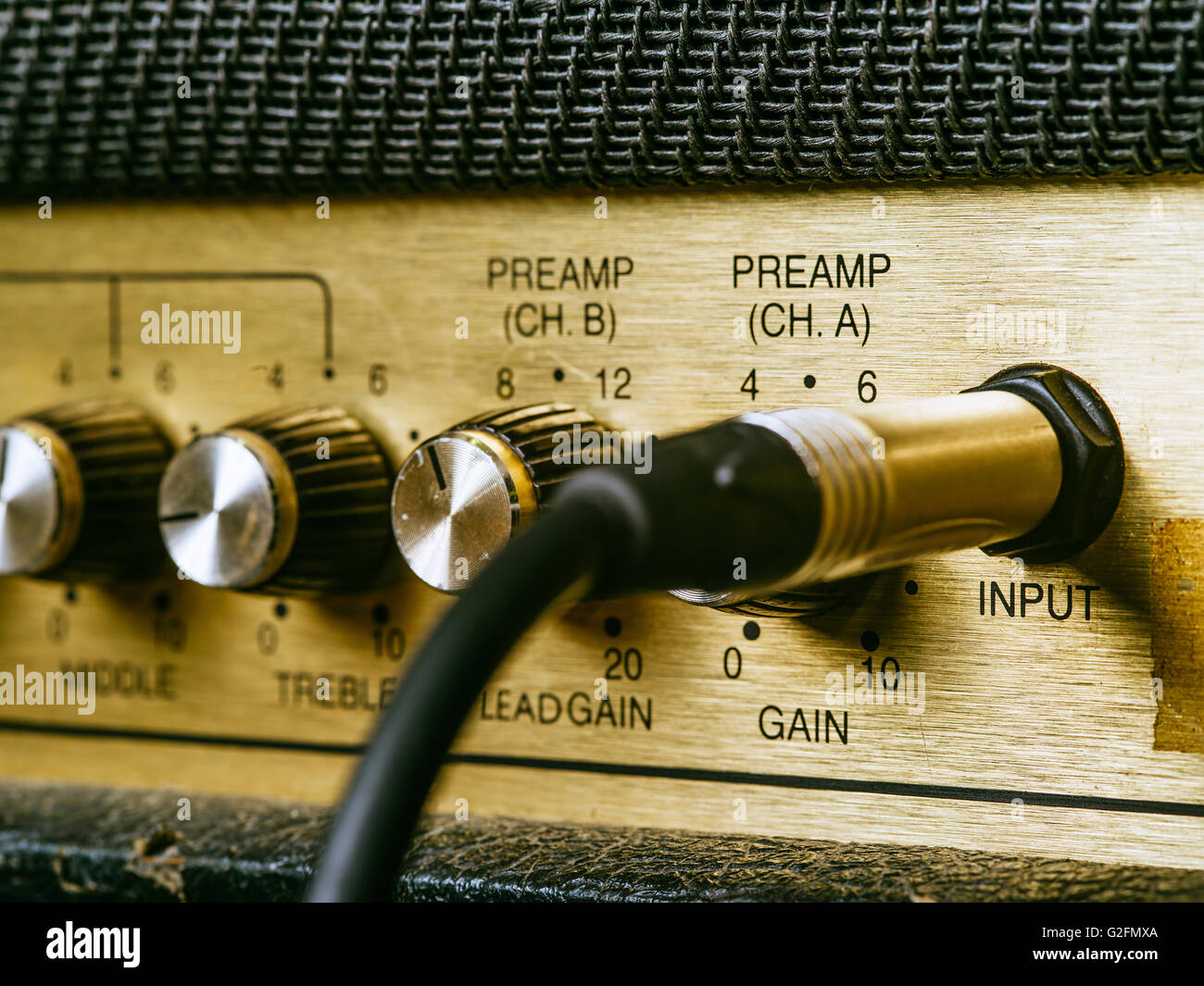 Macro photo of a vintage electric guitar amplifier showing the knobs and input plug Stock Photo