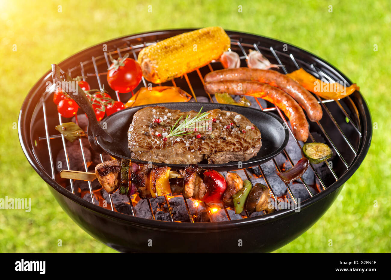 Various kind of meat served on grill with grass on background Stock