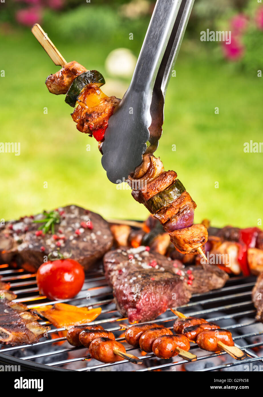 Full grill and meat skewer being hold in sticks Stock Photo Alamy