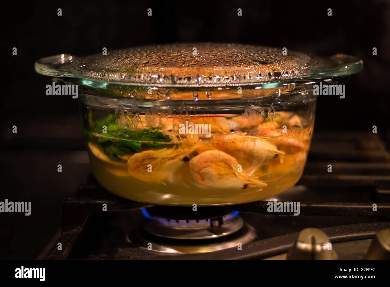 cooking shrimps in transparent glass pot Stock Photo