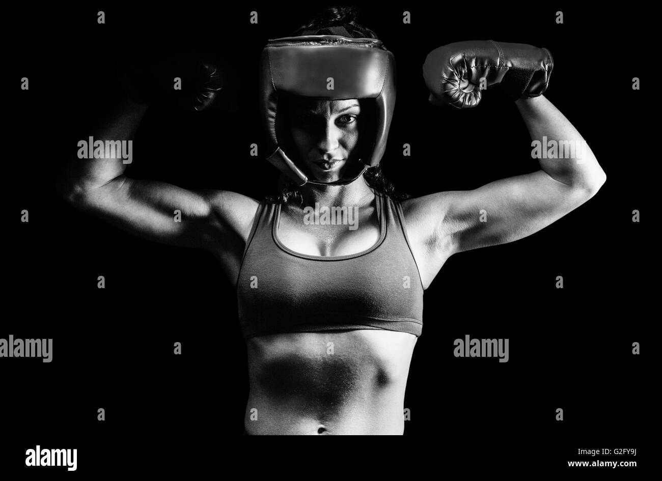 Composite image of portrait of confident female fighter flexing muscles Stock Photo