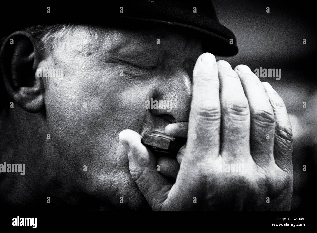 Portrait of a male blues harmonica player with closed eyes and a cap in black and white Stock Photo