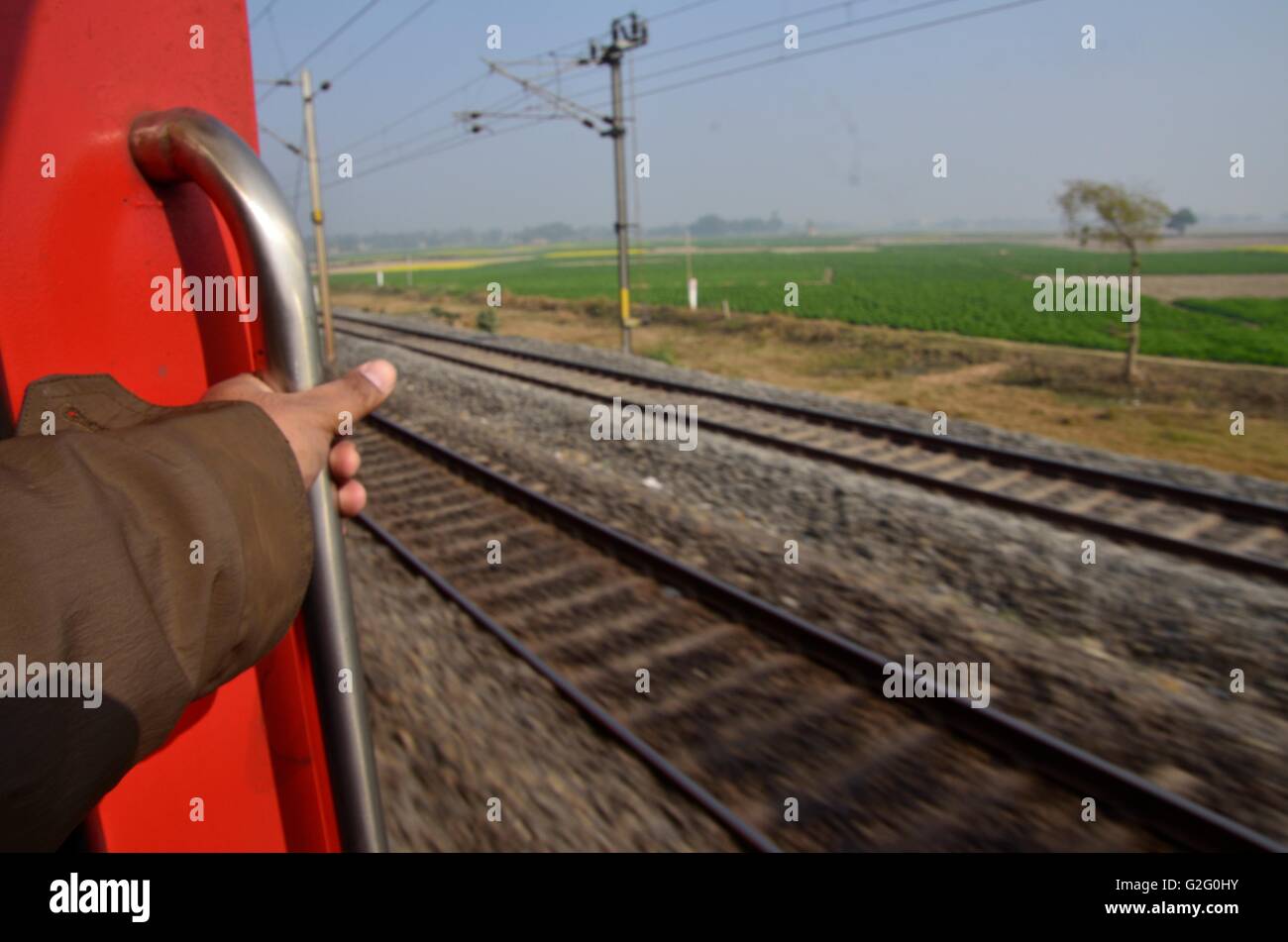 Indian countryside as viewed from the footboard of a running train