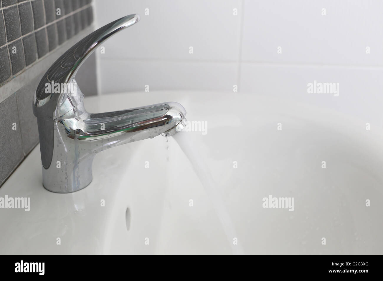 Bathroom silver faucet and have flowing water in concept of saving water. Stock Photo