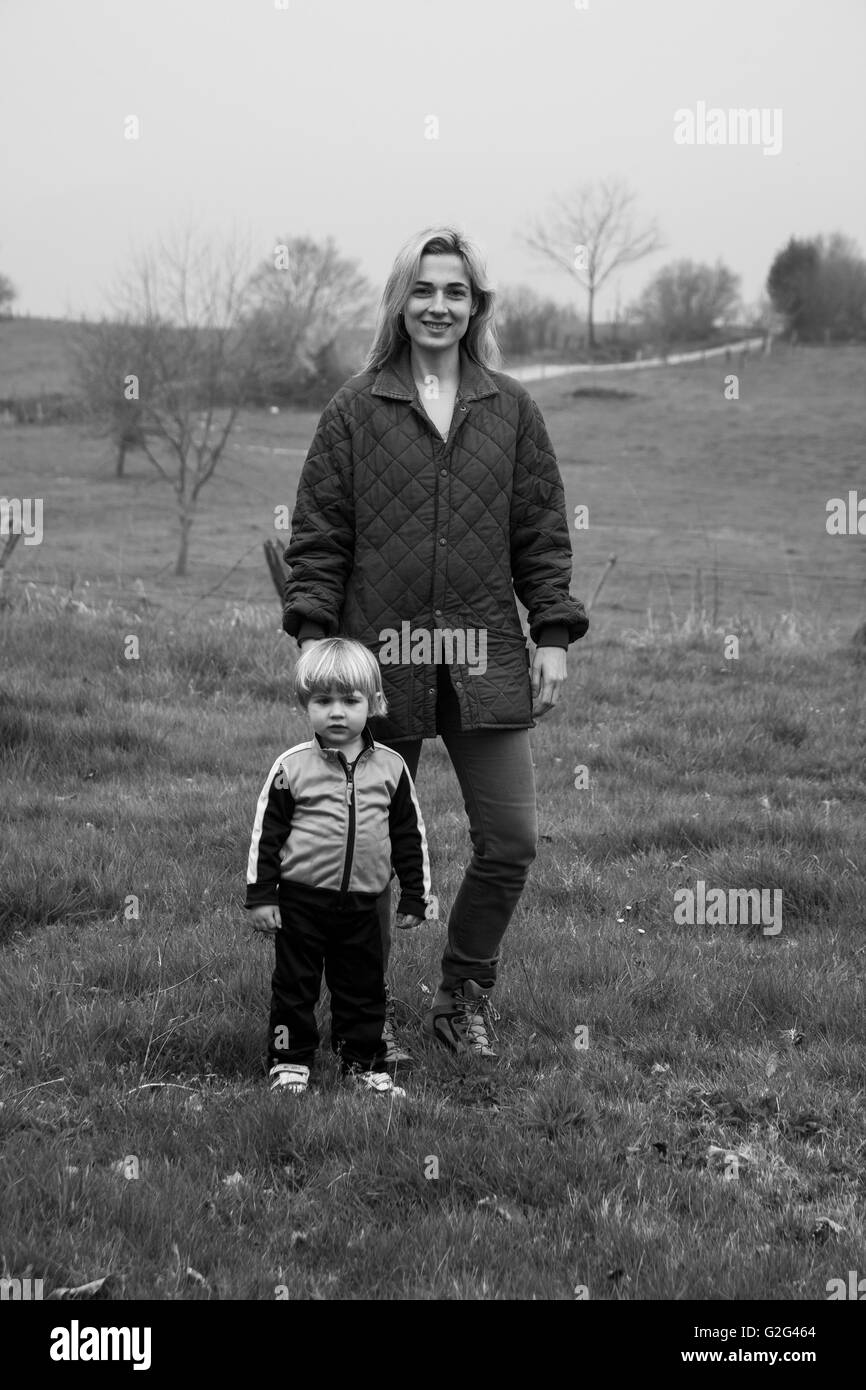 Mother and Young Son  Standing in Grassy Field, Portrait Stock Photo
