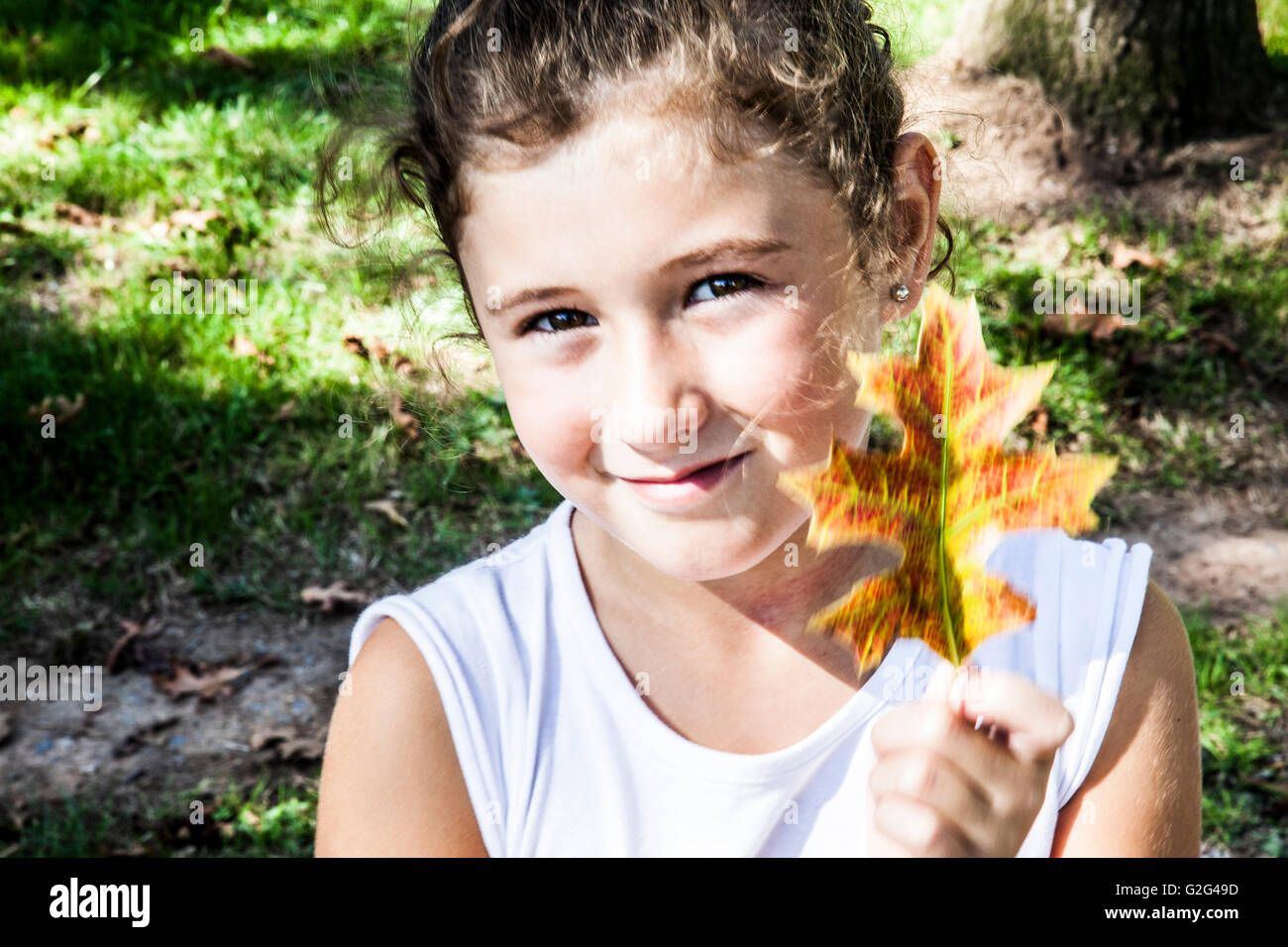 Smiling Girl Holding Leaf Stock Photo - Alamy