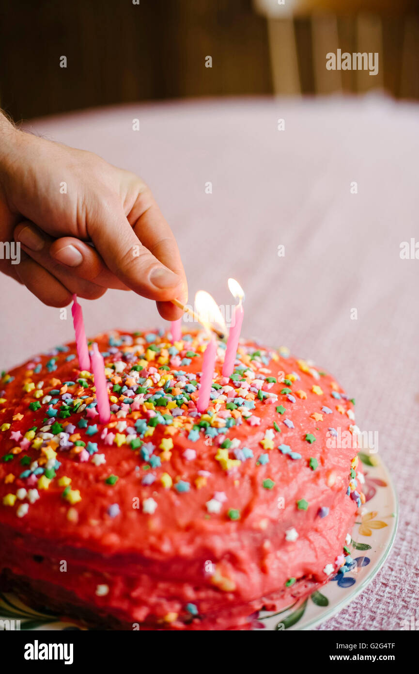 Cake With Pink Icing and Star Sprinkles Being Lit With Candles Stock ...