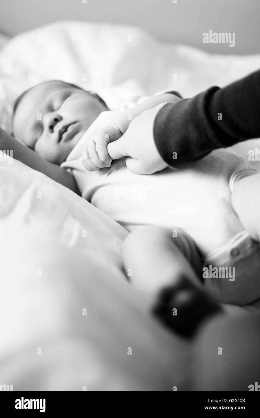 Newborn Baby Holding Child's Finger Stock Photo