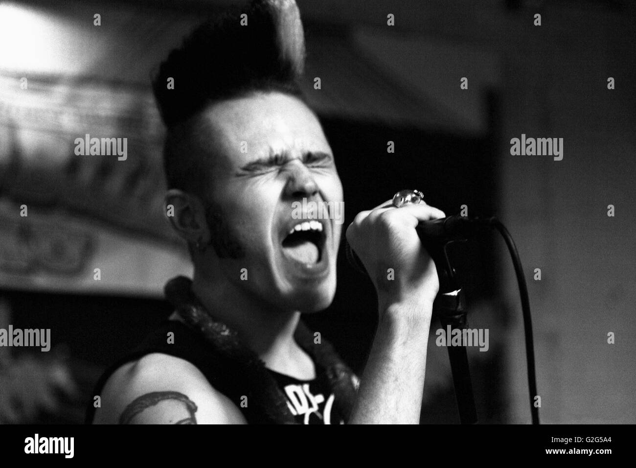 Male Band Singer Screaming into Microphone Stock Photo