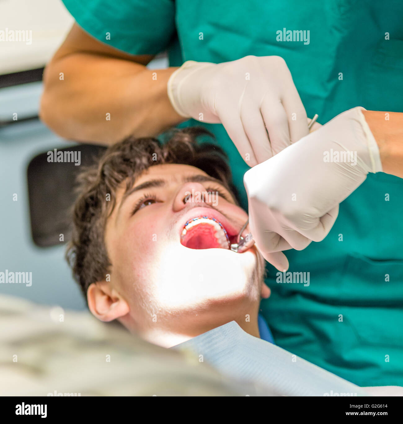 guy on the dentist chair while the orthodontist is checking the edgewise appliance