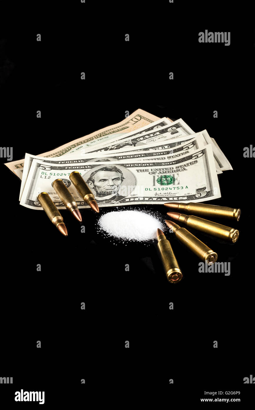 bullets on dollar banknotes with white drug powder on black background Stock Photo