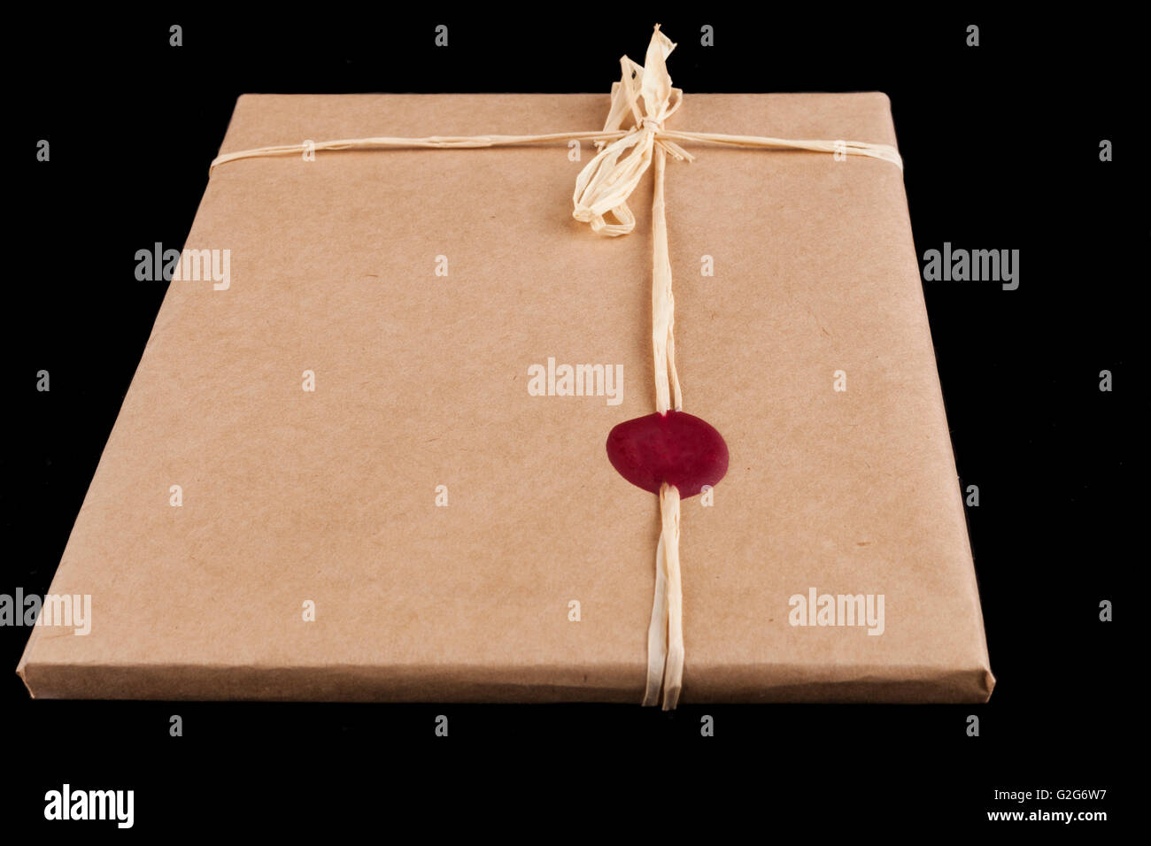 https://c8.alamy.com/comp/G2G6W7/old-brown-wrapping-paper-gift-close-up-with-tied-bow-and-red-wax-seal-G2G6W7.jpg