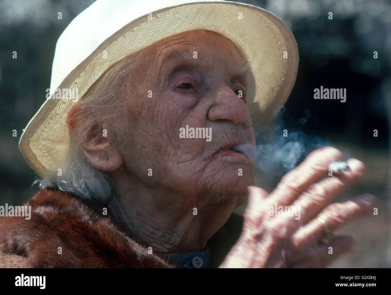 A 99-year-old woman smoking a cigarette (Pall Mall without filter) Stock Photo