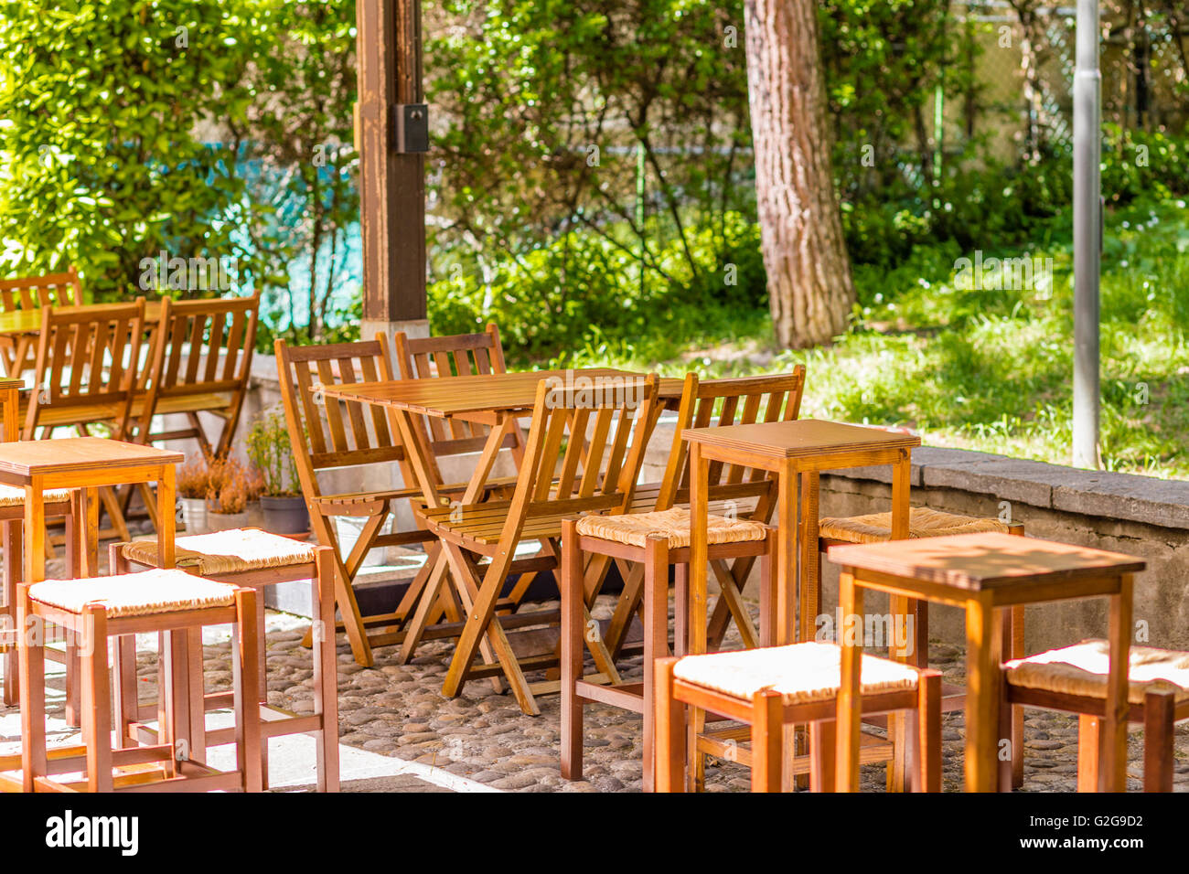 wooden chairs and tables in a bar with garden Stock Photo - Alamy