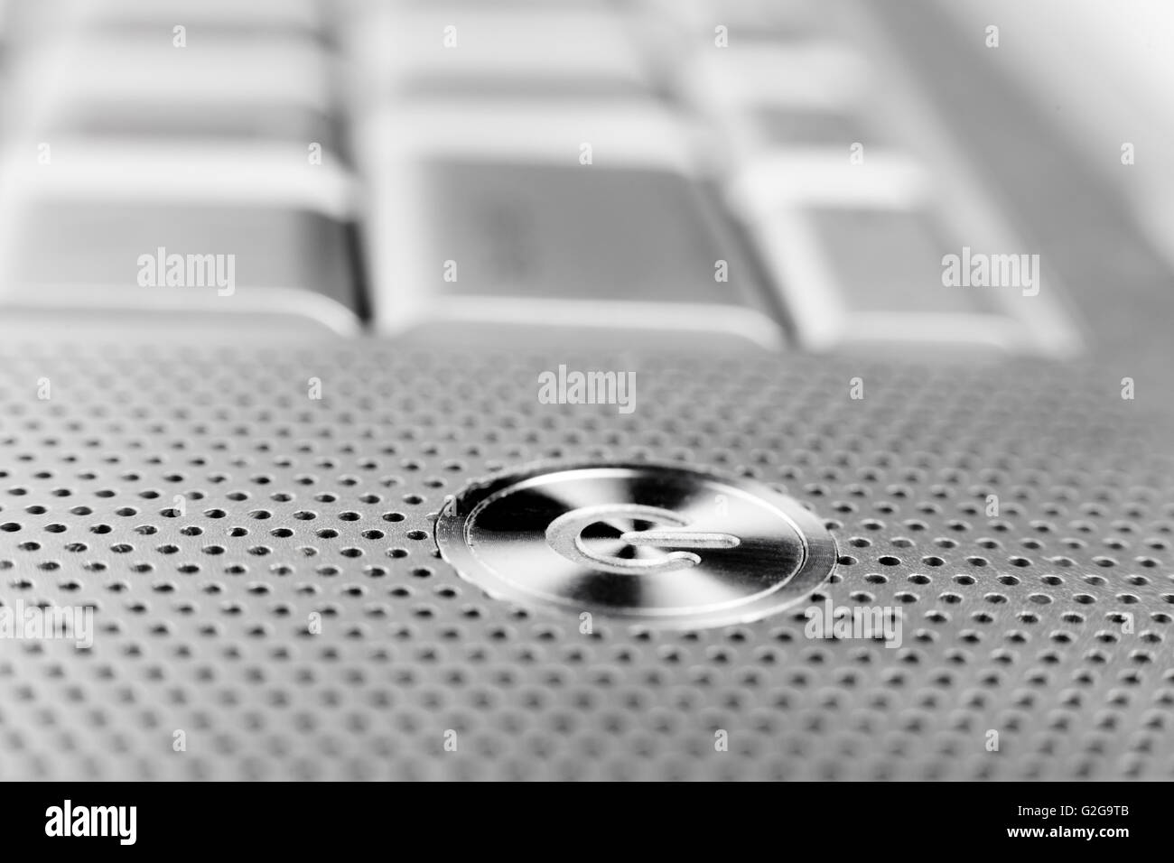silver color laptop power button macro closeup  with holes grid arround Stock Photo