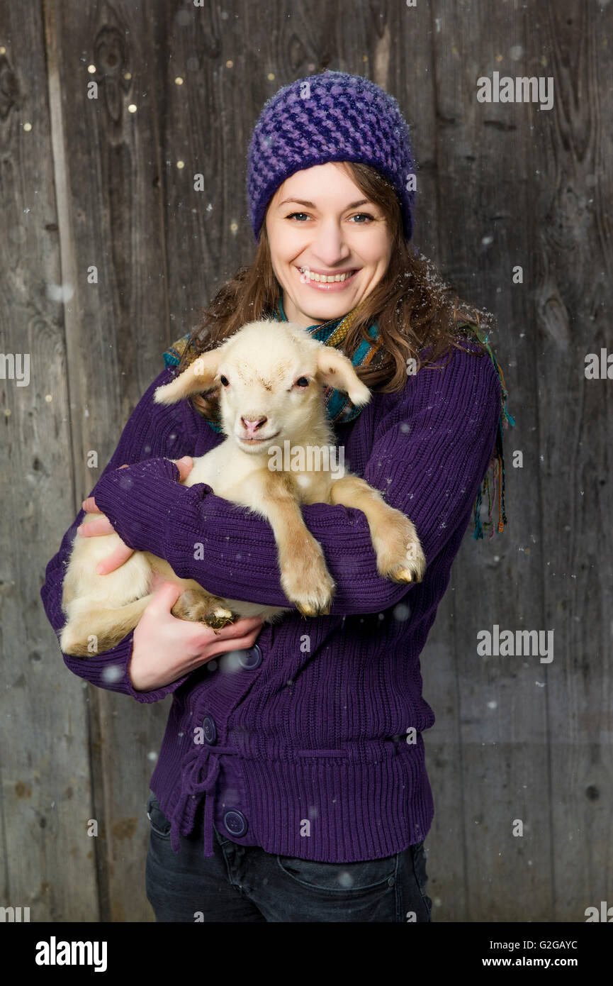 Woman holding a lamb in her arms Stock Photo Alamy