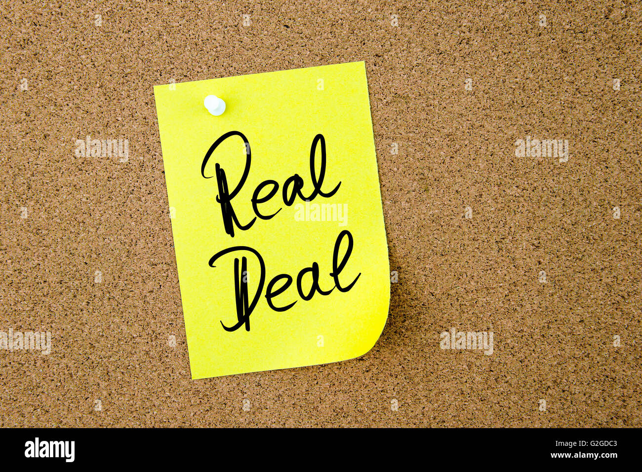 Business Acronym RD Real Deal written on yellow paper note pinned on cork board with white thumbtack, copy space available Stock Photo