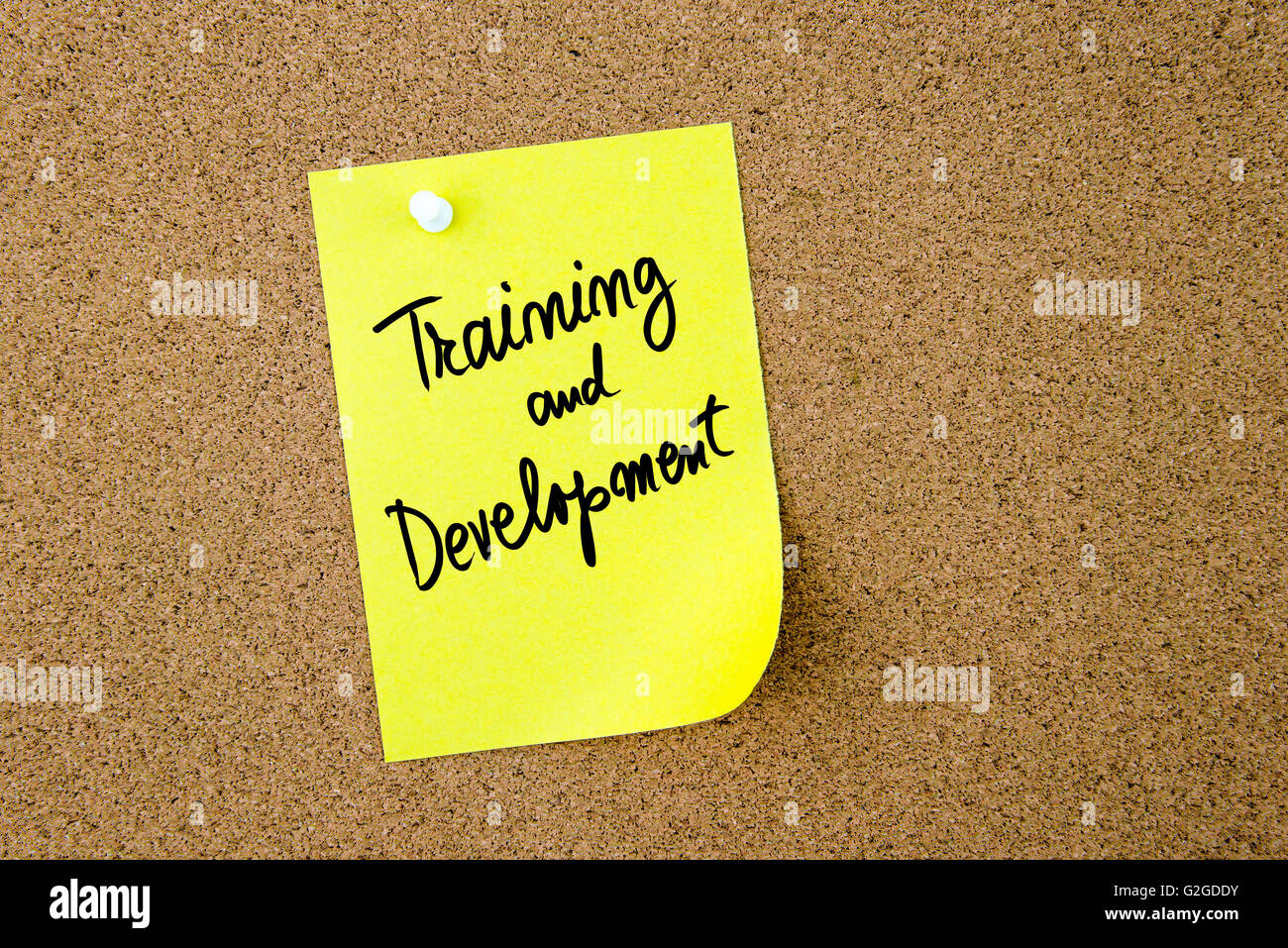 Training and Development written on yellow paper note pinned on cork ...
