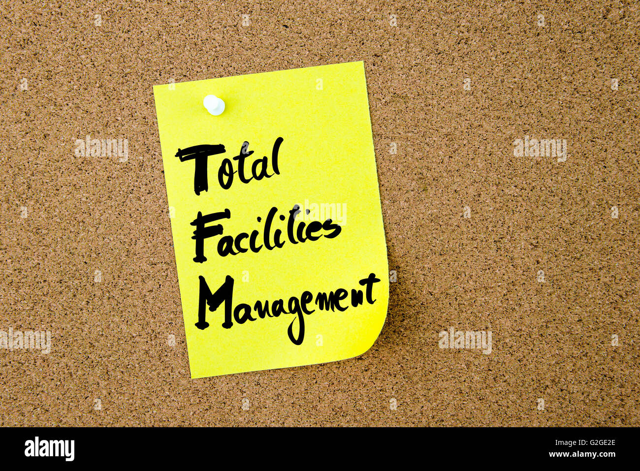 Business Acronym TFM as Total Facilities Management written on yellow paper note pinned on cork board with white thumbtack, copy space available Stock Photo