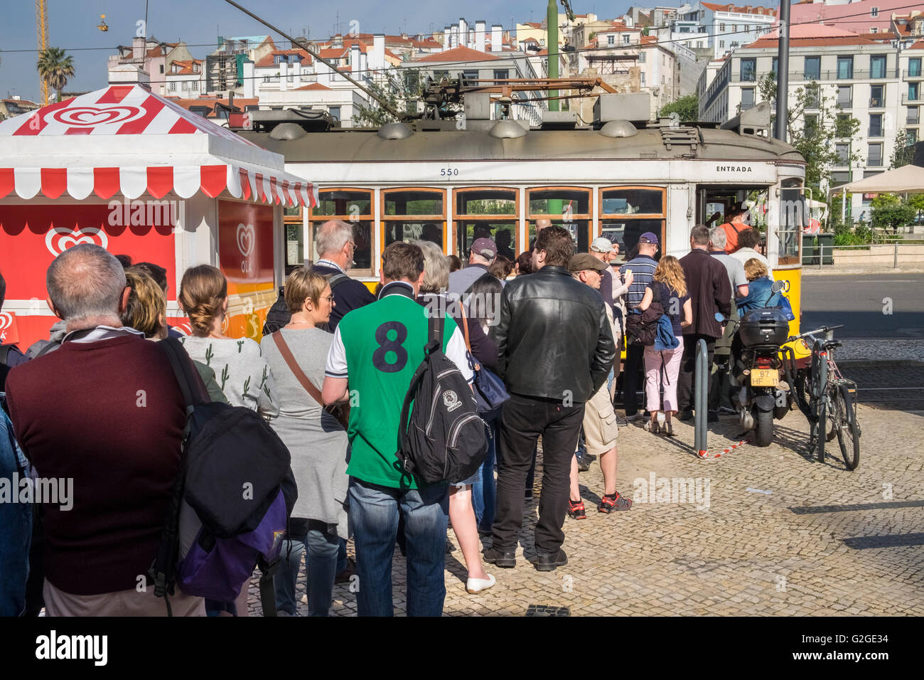 Tourists in a large queue waiting for popular number 28 Tram, Lisbon, Portugal Stock Photo