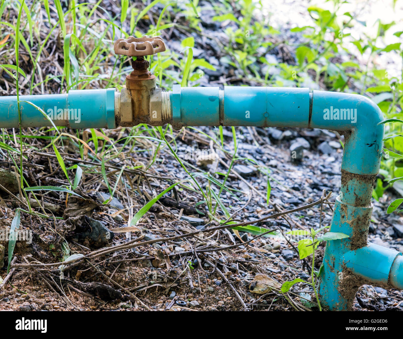 Small PVC pipe with old steel valve for countryside farm Stock Photo