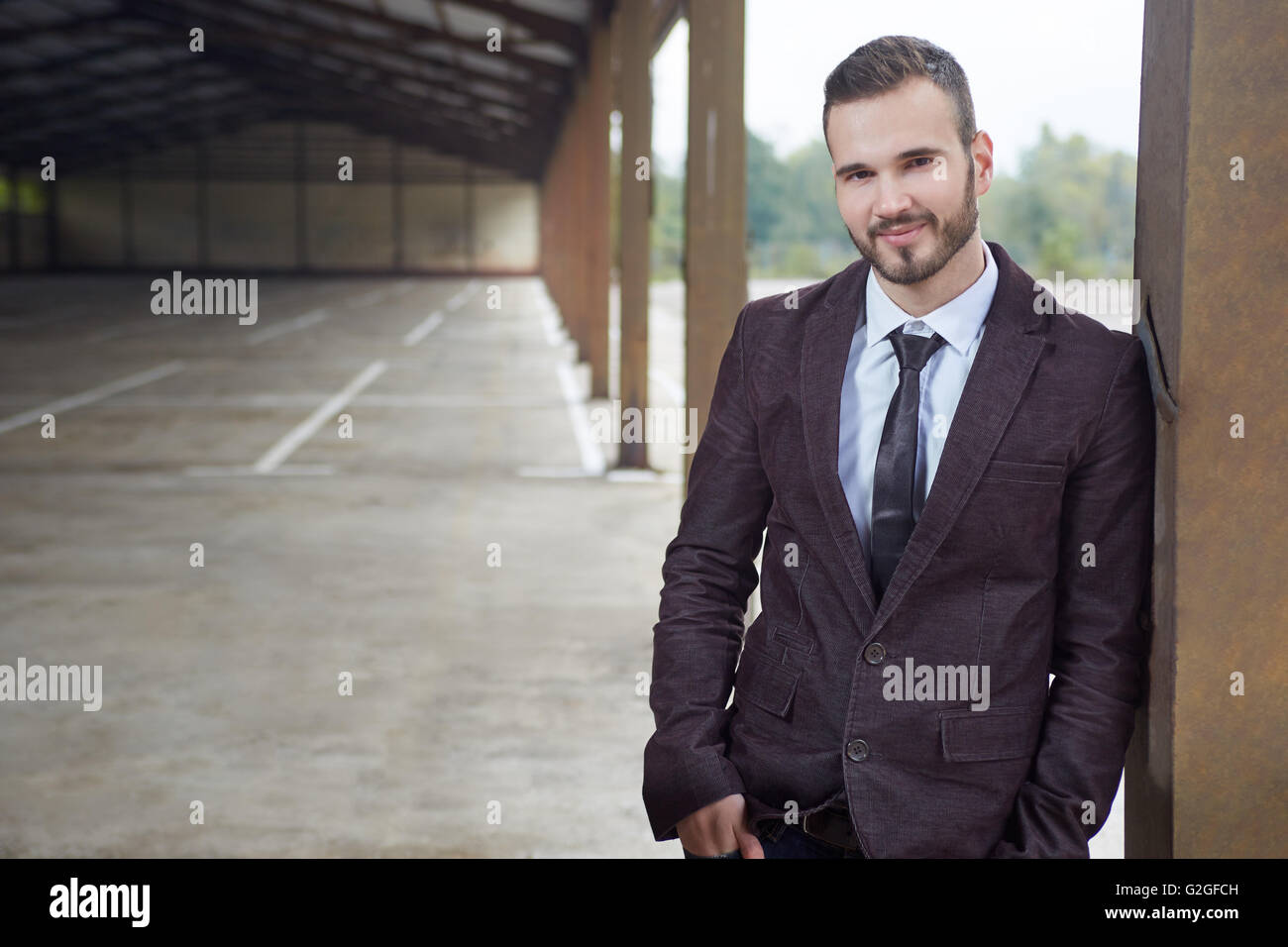 Smiling business man standing outside office building Stock Photo - Alamy