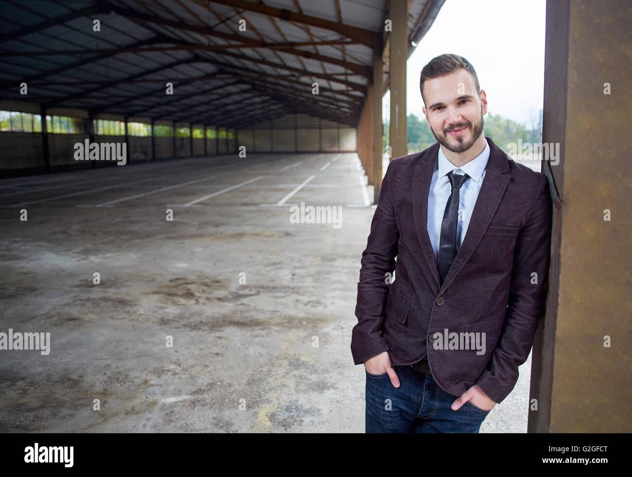 Smiling business man standing outside office building Stock Photo - Alamy
