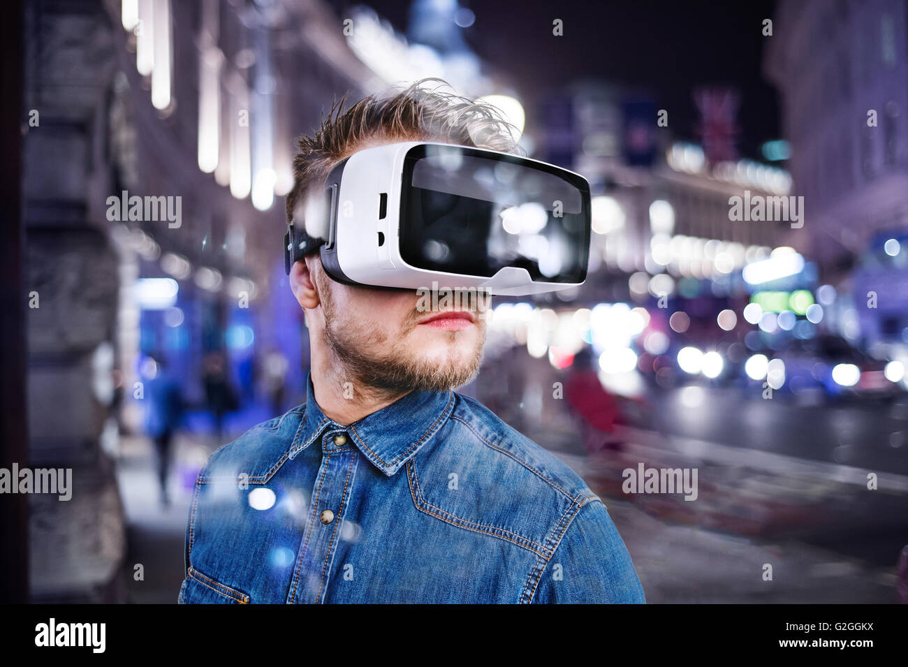 Hipster man in denim shirt wearing virtual reality goggles. City at ...