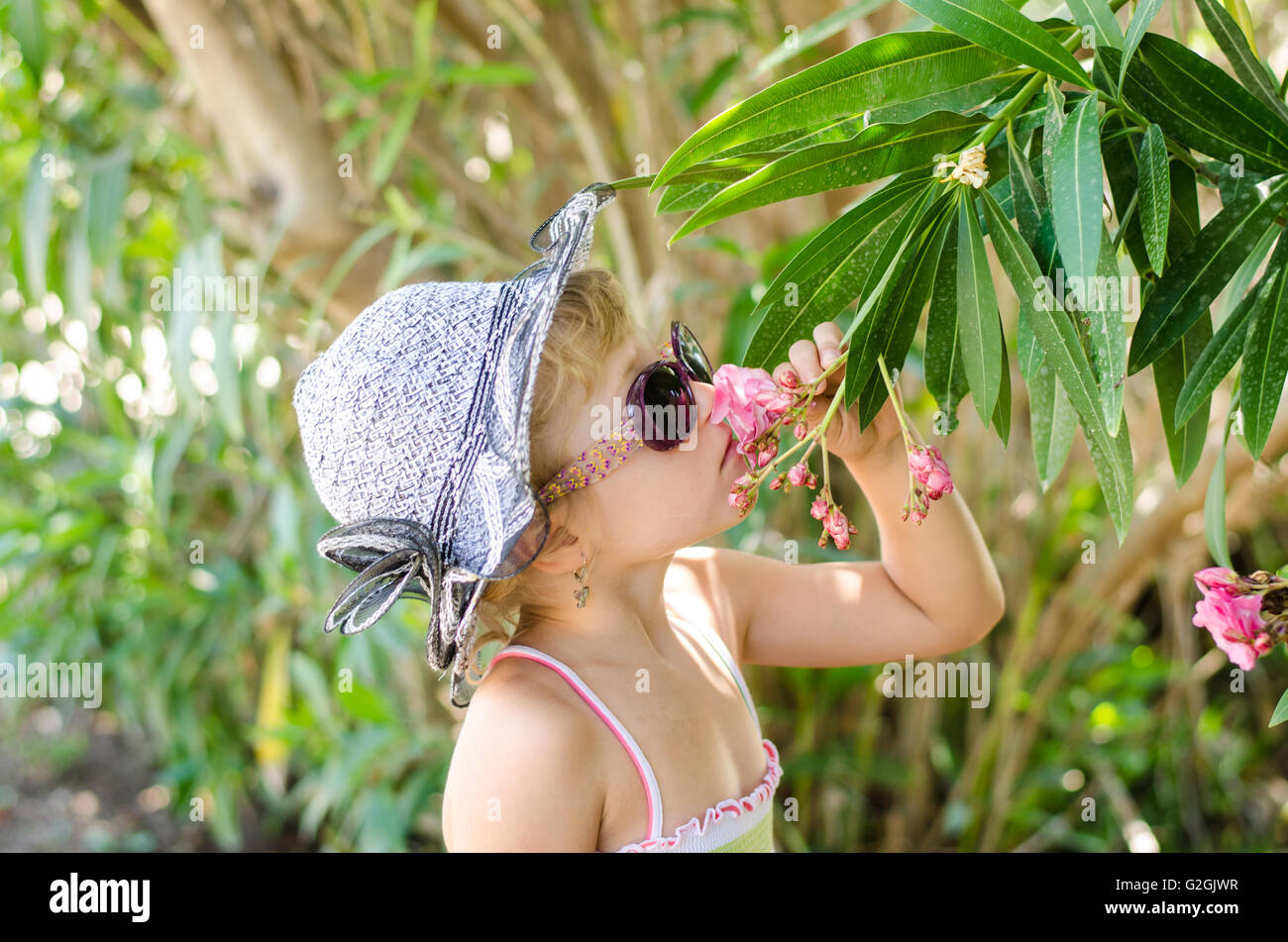 beautiful blond girl smelling flowers Stock Photo - Alamy