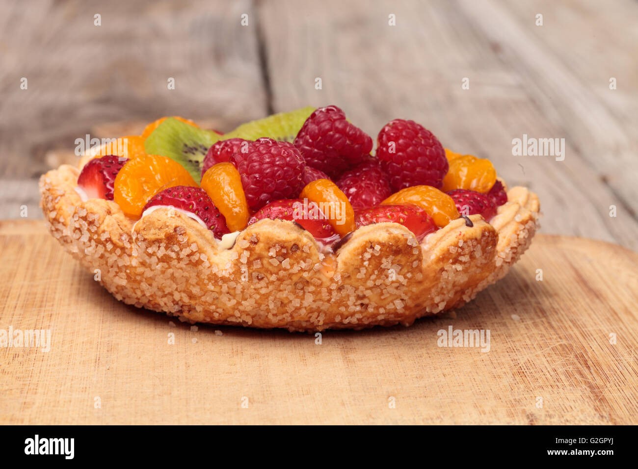 Fruit tart with a yellow custard, ladyfinger cookie shell crust