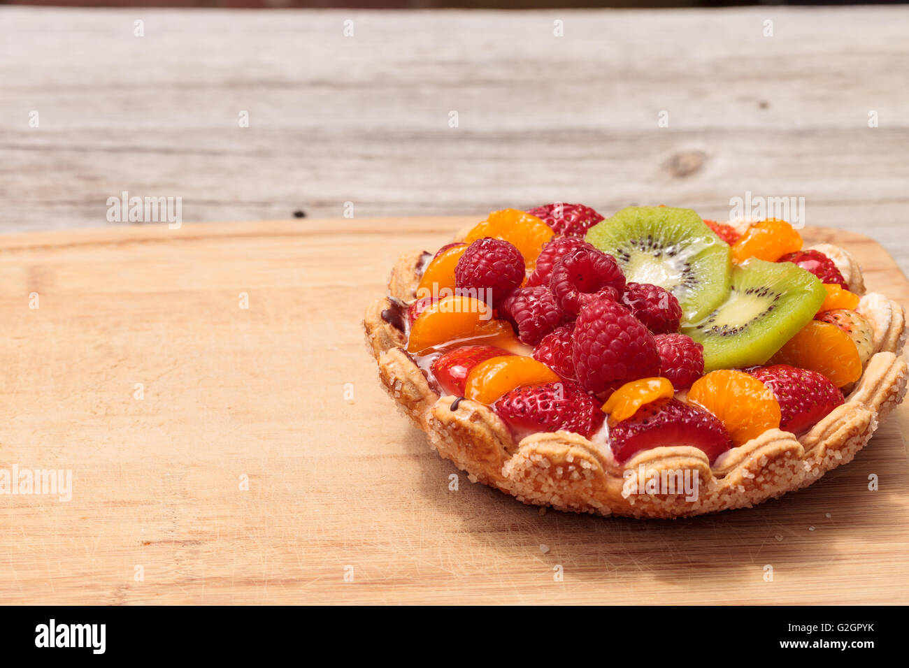Fruit tart with a yellow custard, ladyfinger cookie shell crust